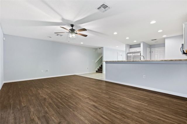 unfurnished living room with ceiling fan and wood-type flooring