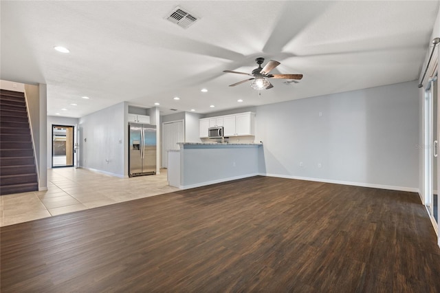 unfurnished living room with light wood-type flooring and ceiling fan