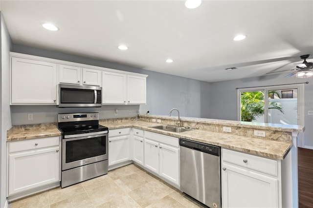 kitchen featuring sink, kitchen peninsula, ceiling fan, and stainless steel appliances