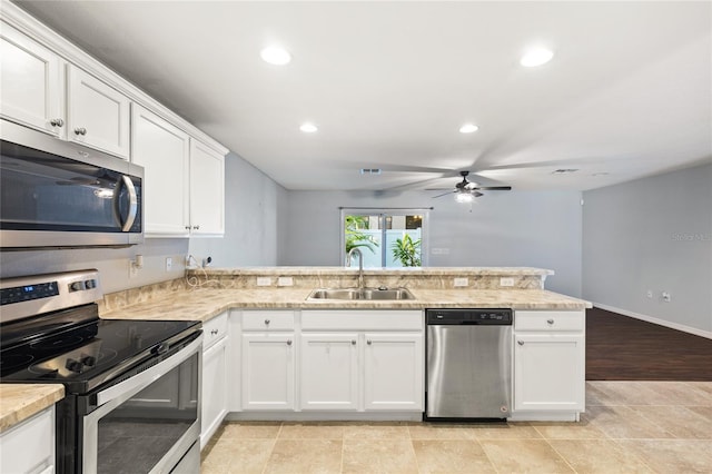 kitchen with light tile patterned floors, ceiling fan, sink, appliances with stainless steel finishes, and kitchen peninsula