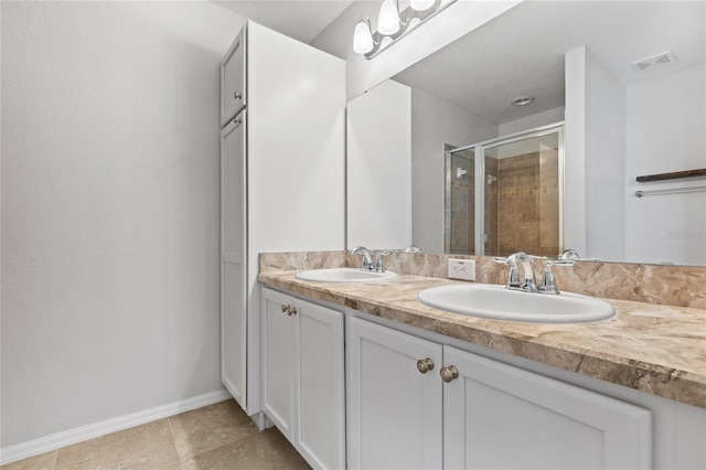 bathroom featuring tile patterned flooring and dual bowl vanity