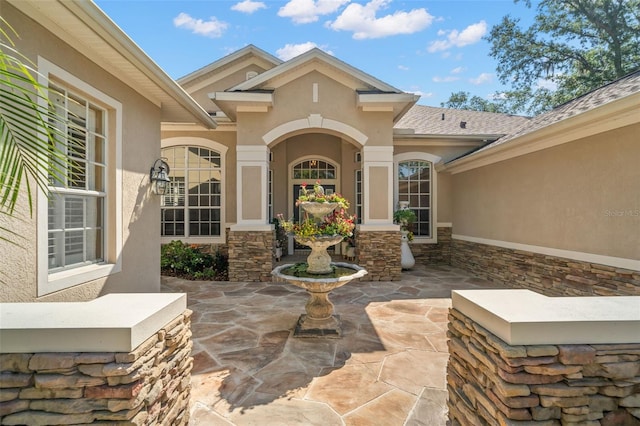 view of exterior entry with a patio area