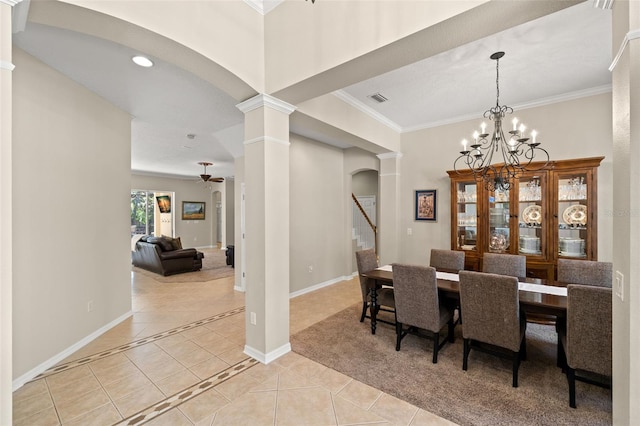 dining space featuring ceiling fan with notable chandelier, crown molding, decorative columns, and light tile floors