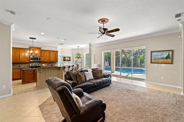 tiled living room with ceiling fan with notable chandelier, a wealth of natural light, and ornamental molding