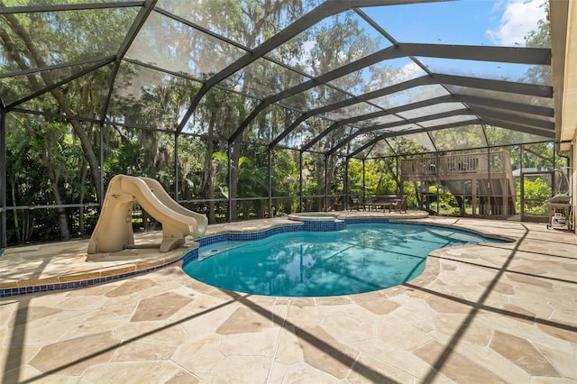 view of swimming pool with a patio area, an in ground hot tub, a lanai, and a water slide