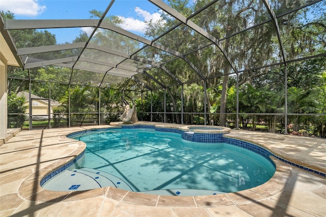 view of swimming pool with glass enclosure, an in ground hot tub, and a patio area