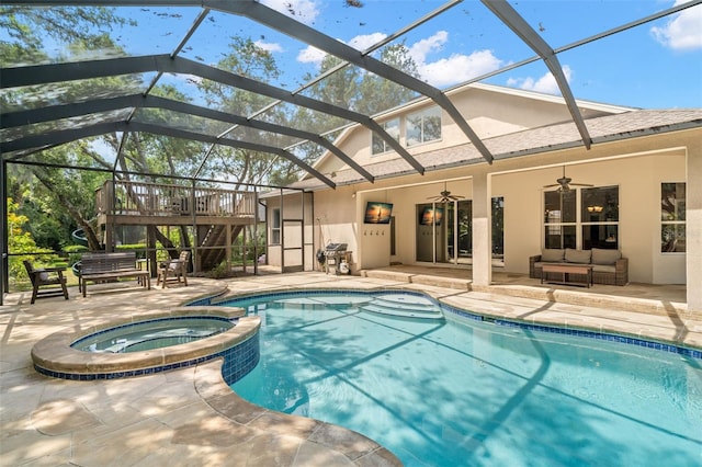 view of swimming pool featuring a patio, glass enclosure, an in ground hot tub, and ceiling fan