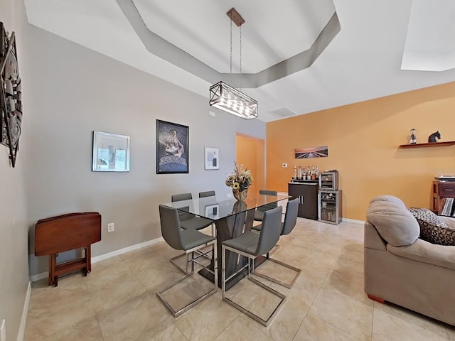 tiled dining room featuring a tray ceiling