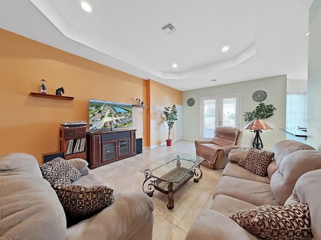 living room with french doors and a tray ceiling