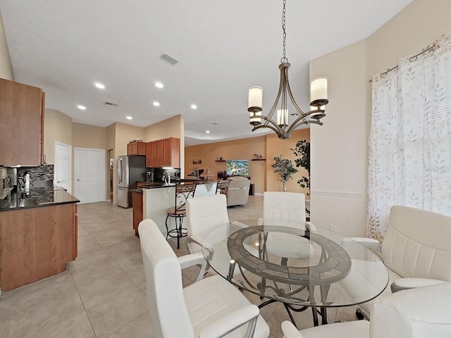 tiled dining space with a notable chandelier and sink