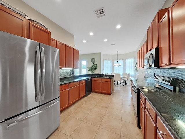 kitchen featuring sink, hanging light fixtures, stainless steel appliances, light tile patterned flooring, and decorative backsplash