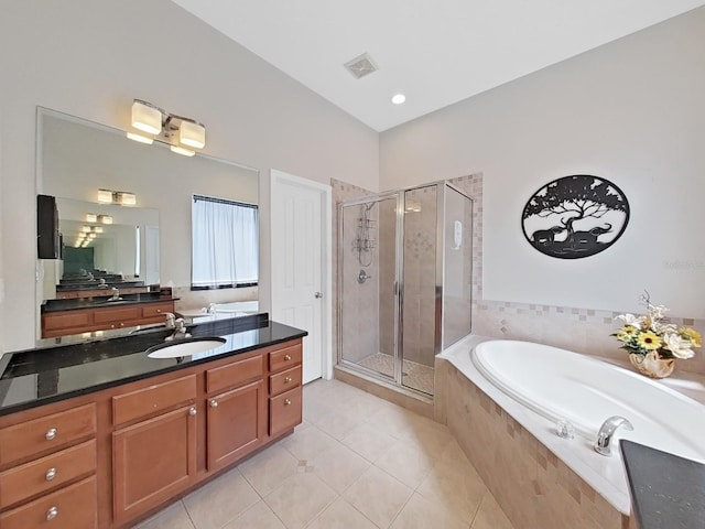 bathroom with tile patterned floors, vanity, and shower with separate bathtub