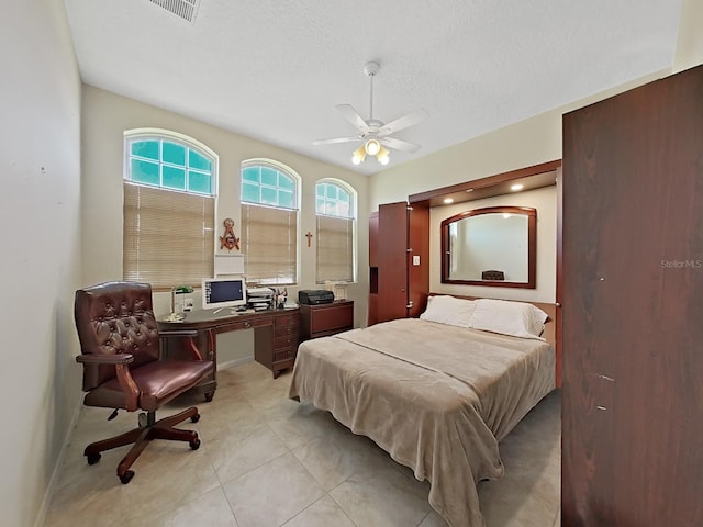 bedroom with a textured ceiling, ceiling fan, and light tile patterned flooring