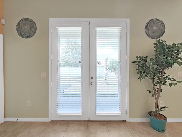 doorway with light tile patterned floors and french doors