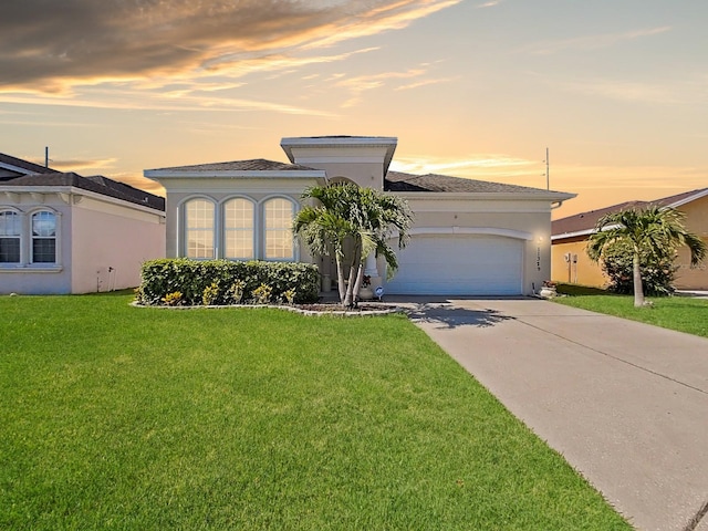 view of front of property featuring a garage and a yard