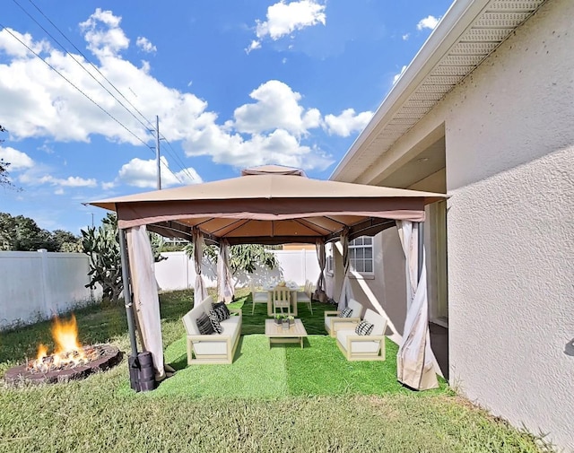 view of yard with a gazebo and an outdoor living space with a fire pit