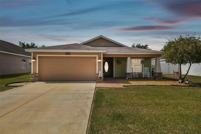 view of front of property with a garage and a yard