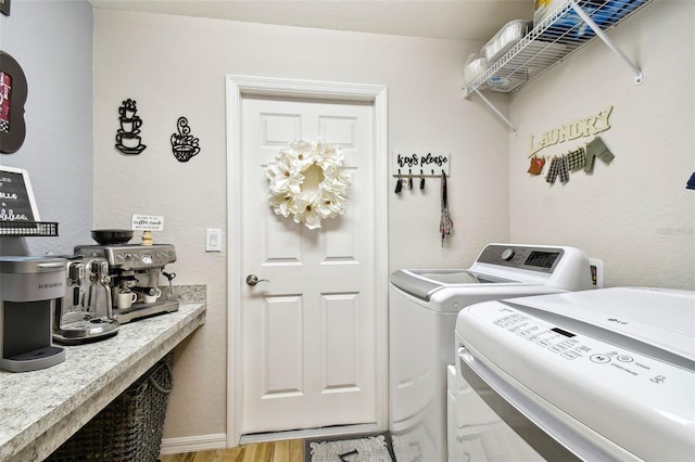 laundry room featuring light wood-type flooring and washer and dryer