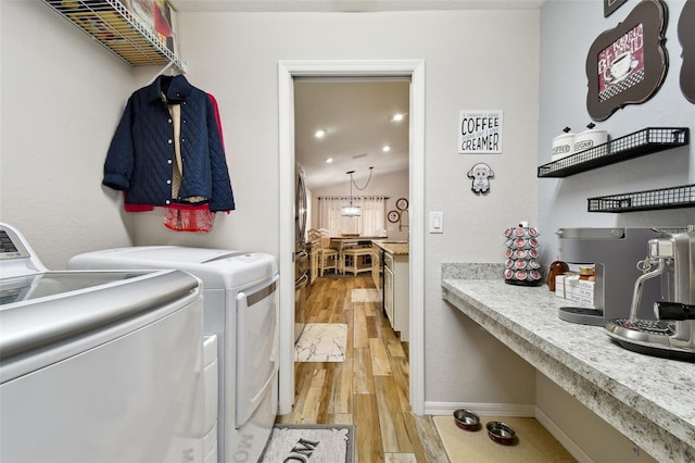 laundry area featuring light hardwood / wood-style flooring and washing machine and dryer