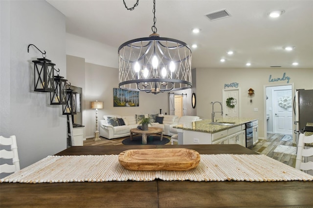 dining area with a chandelier, light hardwood / wood-style flooring, and sink