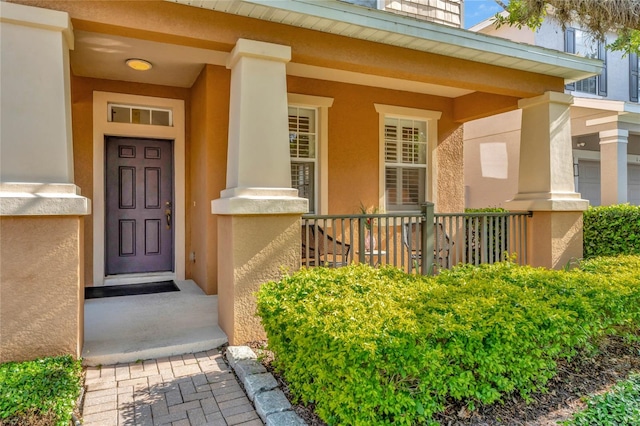 view of exterior entry featuring covered porch