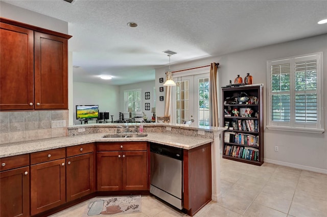 kitchen with stainless steel dishwasher, light stone counters, kitchen peninsula, and sink