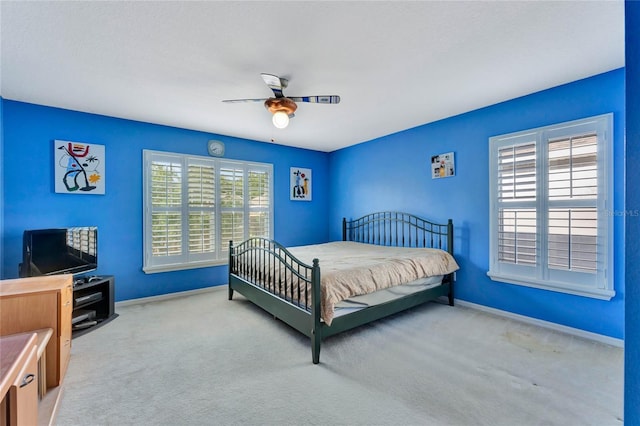 carpeted bedroom with multiple windows and ceiling fan