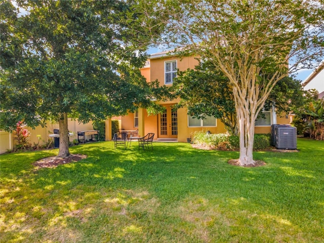 view of yard featuring french doors and cooling unit