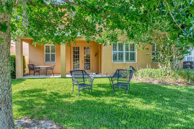 view of yard featuring a patio and french doors