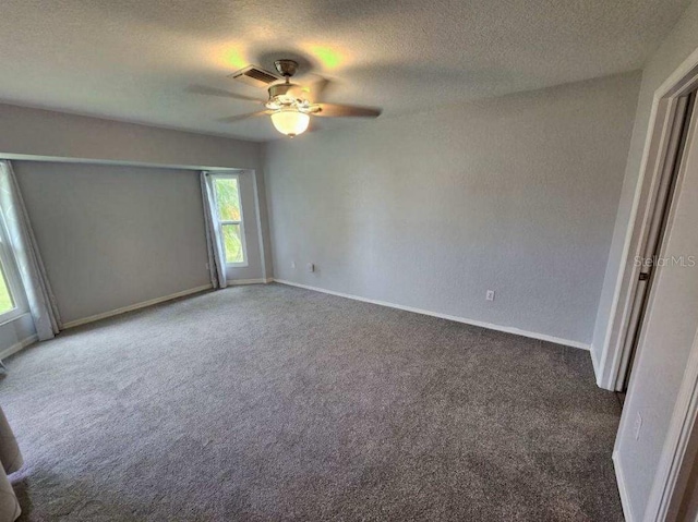 empty room featuring dark carpet, a textured ceiling, and ceiling fan