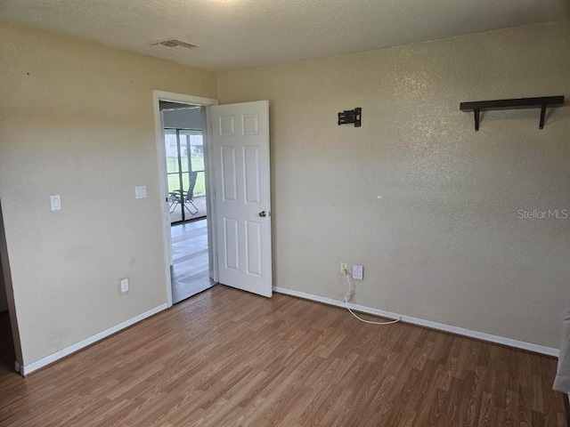 empty room with hardwood / wood-style flooring