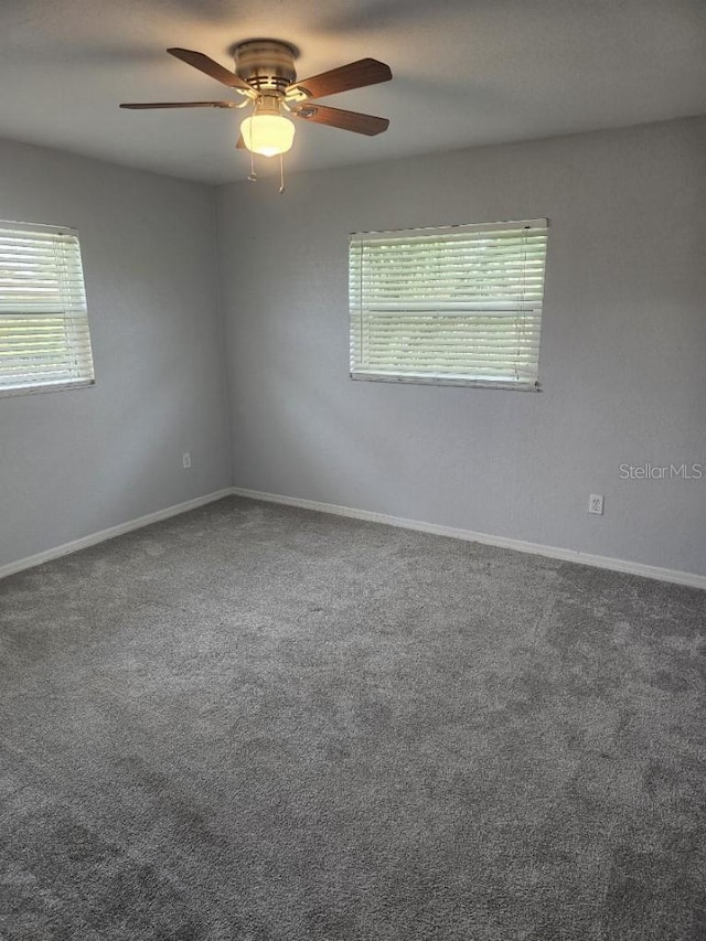 empty room featuring ceiling fan and carpet