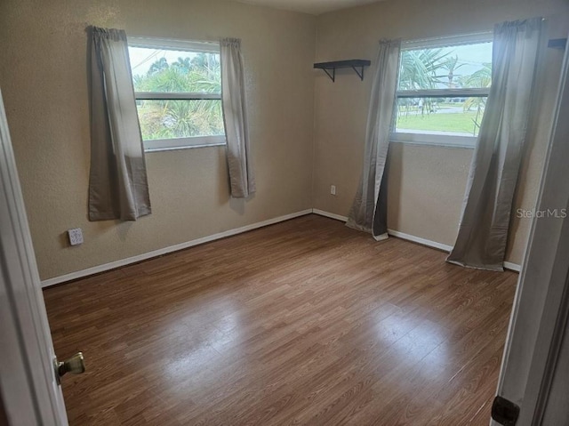 unfurnished room with wood-type flooring