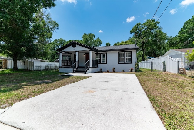 view of front of home featuring a front yard, covered porch, fence, and stucco siding