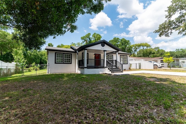 view of front of house featuring a porch, fence private yard, a front yard, and stucco siding