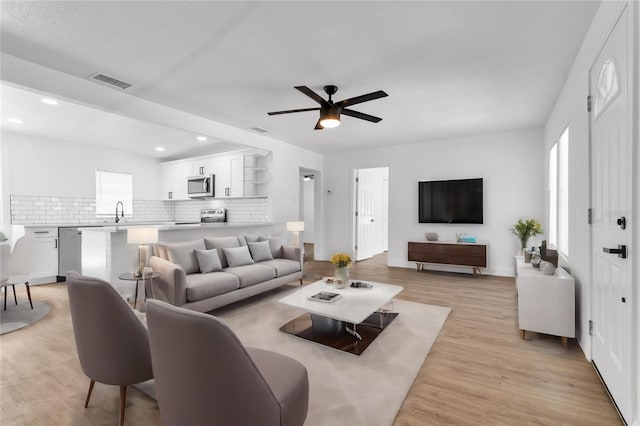 living area featuring a ceiling fan, recessed lighting, visible vents, and light wood-style flooring