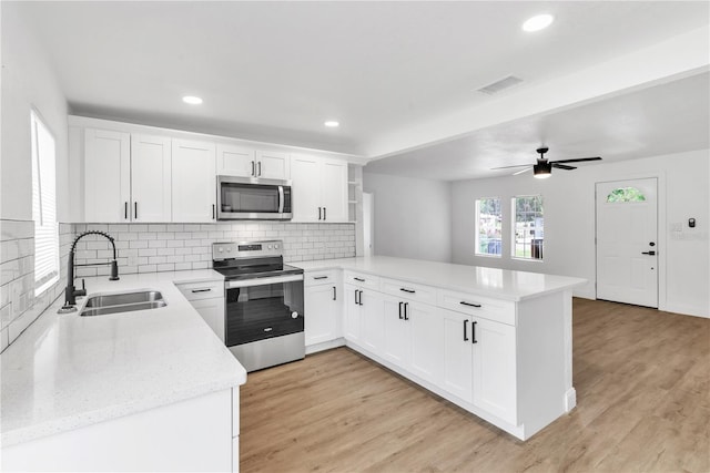 kitchen featuring light hardwood / wood-style flooring, stainless steel appliances, white cabinetry, ceiling fan, and kitchen peninsula