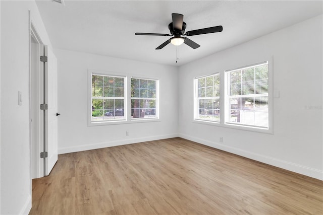 empty room with ceiling fan and light hardwood / wood-style flooring