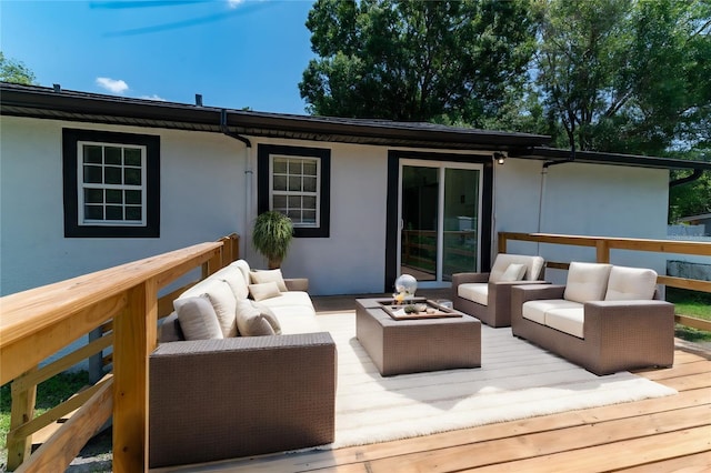 wooden terrace with an outdoor living space with a fire pit