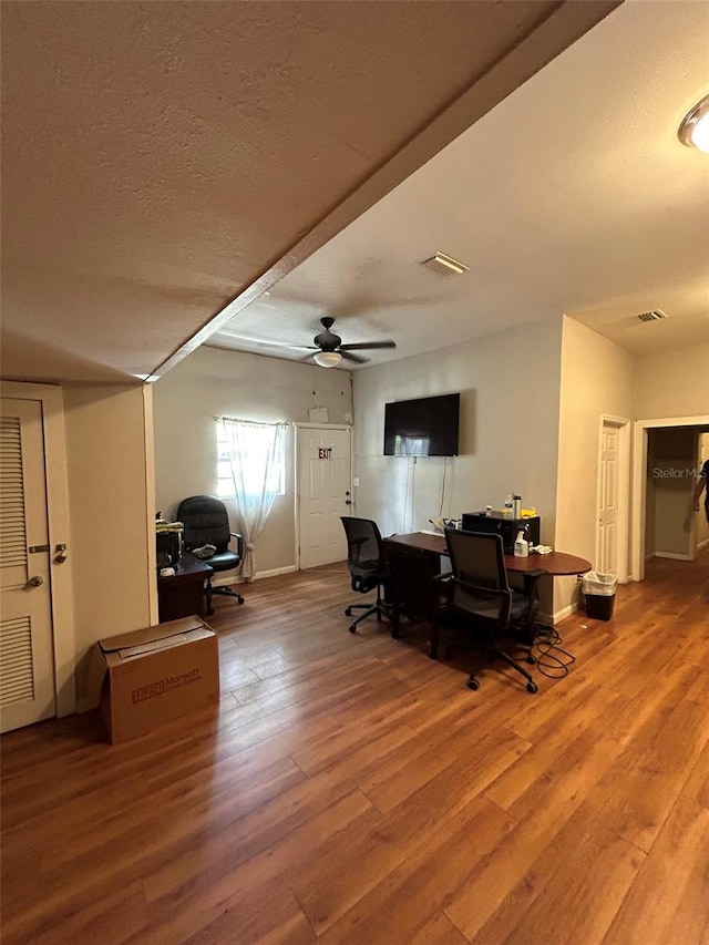 living room featuring a textured ceiling, ceiling fan, and hardwood / wood-style flooring