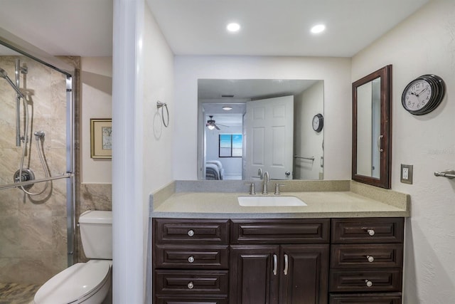 bathroom with ceiling fan, an enclosed shower, vanity, and toilet