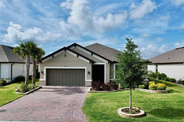 ranch-style home with a garage, a shingled roof, decorative driveway, stucco siding, and a front lawn