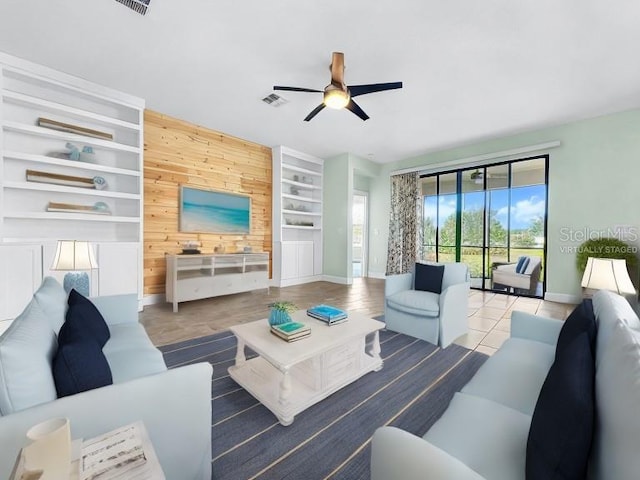 tiled living room featuring ceiling fan and built in features