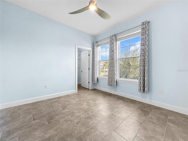 spare room with ceiling fan and tile patterned floors