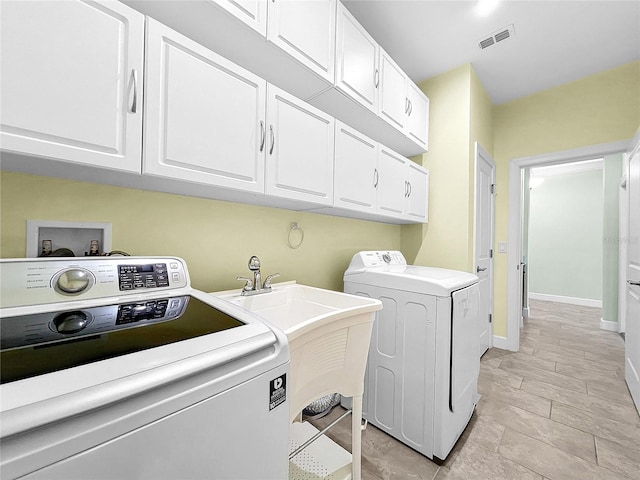 laundry room featuring cabinets, light tile patterned floors, and separate washer and dryer