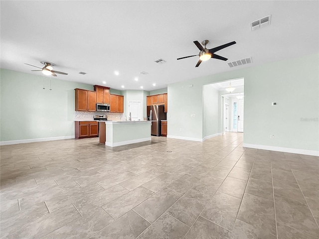 unfurnished living room featuring visible vents and a ceiling fan