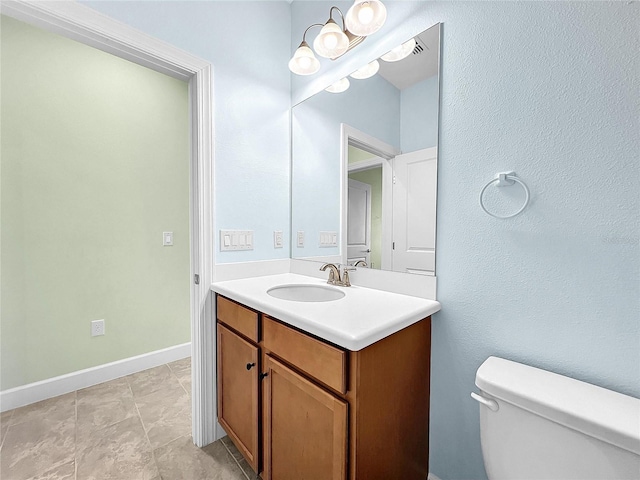 half bathroom featuring baseboards, vanity, and toilet