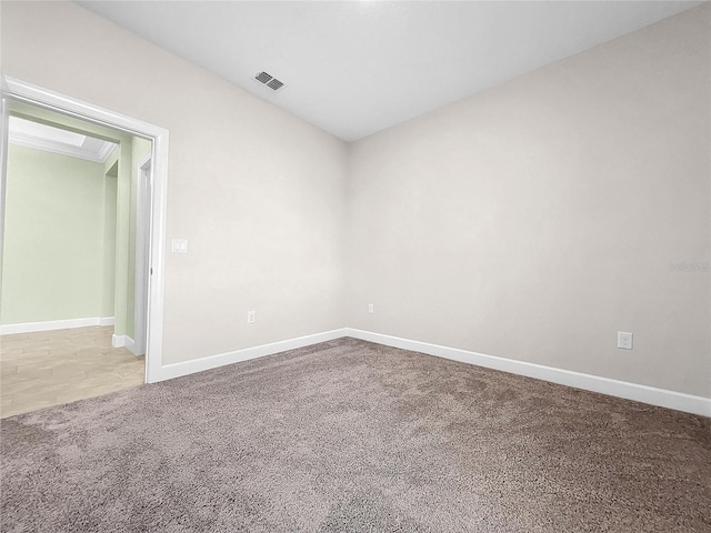 spare room featuring baseboards, visible vents, and carpet flooring