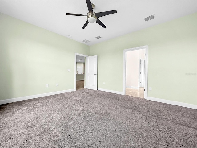 unfurnished bedroom featuring baseboards, a ceiling fan, visible vents, and light colored carpet