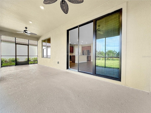 unfurnished sunroom featuring ceiling fan